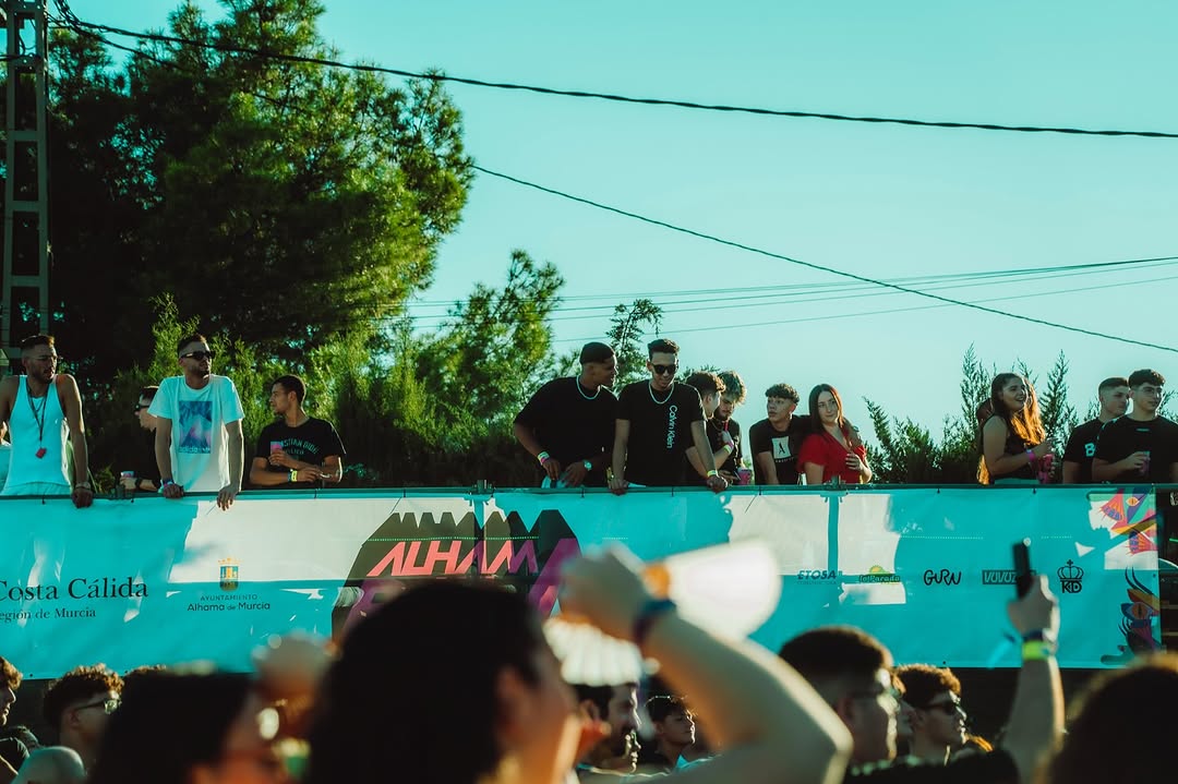 Asistentes asomados a la grada sobre la lona del festival